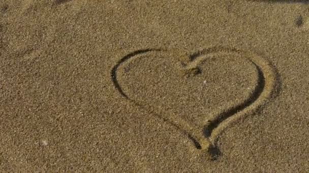 corazón en la playa de arena dorada, el viento sopla arena
. - Metraje, vídeo