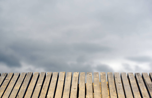 Antigua mesa de madera para un fondo total borroso el cielo con nubes
. - Foto, Imagen