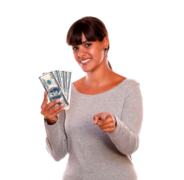 Smiling young woman with money pointing at you - 写真・画像