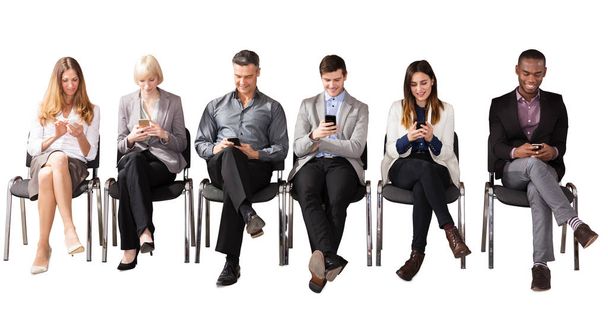 Group Of Multi Ethnic Business People Sitting On Chair Using Cell Phone Against White Background - Photo, Image