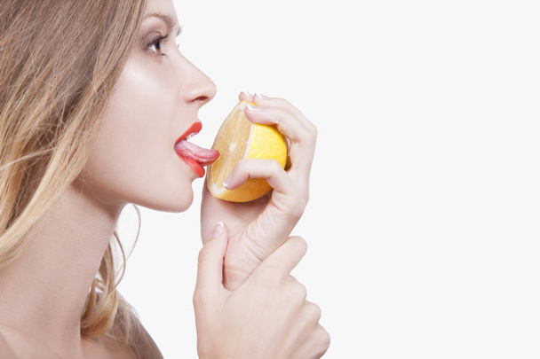woman licking half of lemon - 写真・画像
