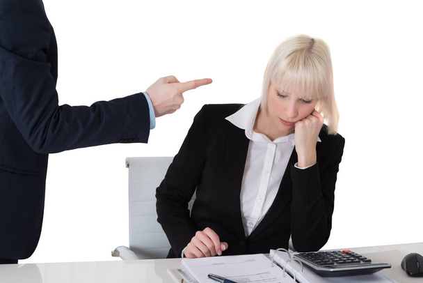 Γκρο πλαν του επιχειρηματία κατσάδα του γυναίκα συνάδελφο στο γραφείο ενάντια σε λευκό φόντο - Φωτογραφία, εικόνα