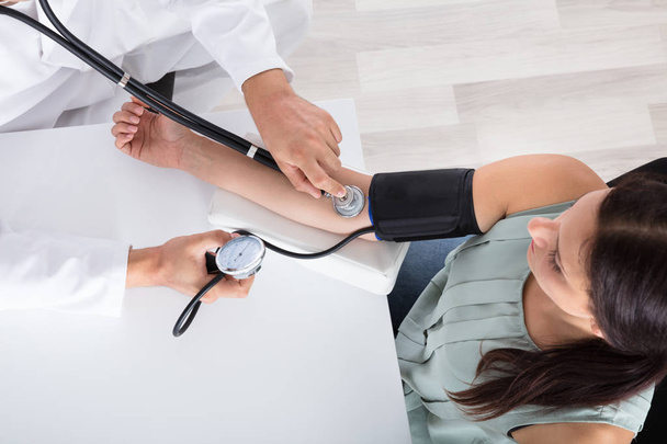 Lekarz sprawdzający ciśnienie krwi - Zdjęcie, obraz