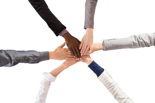 Grupo de empresários multi étnicos empilhando as mãos contra fundo branco
 - Foto, Imagem