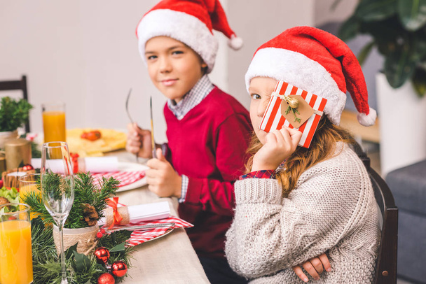brother and sister sitting at christmas table - Photo, Image