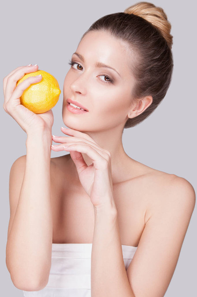 Woman standing with lemon - Zdjęcie, obraz