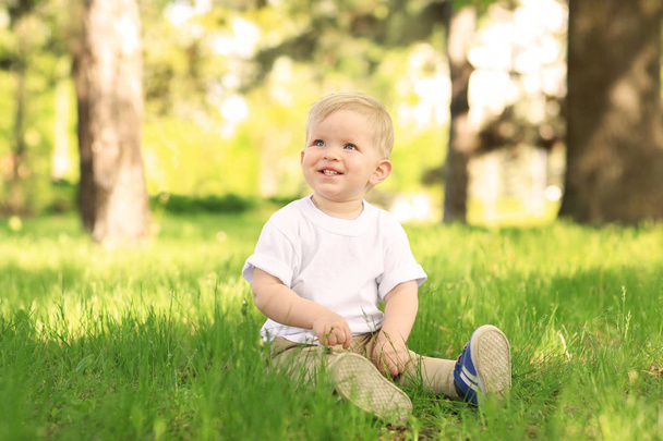 Cute baby boy with dandelion in green park on sunny day - 写真・画像