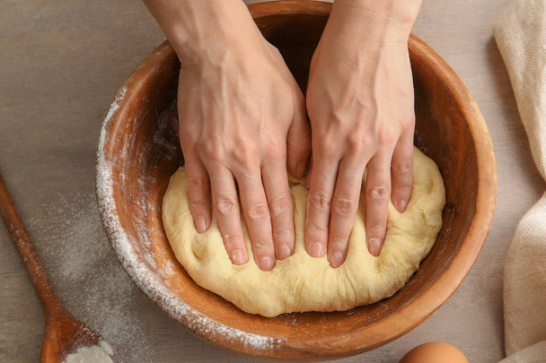 Female chef kneading dough in bowl on kitchen table - Fotoğraf, Görsel