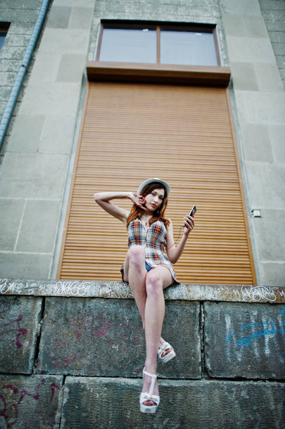 Amazing long legs with hig heels girl wear on hat against shutte - Φωτογραφία, εικόνα