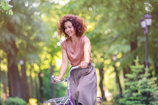 Beautiful young woman with bicycle, outdoors - Фото, зображення