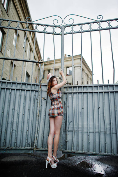 Amazing long legs with hig heels girl wear on hat against iron f - Foto, Bild