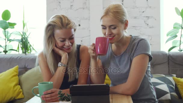 Duas raparigas estão a ver algo no tablet.
 - Filmagem, Vídeo
