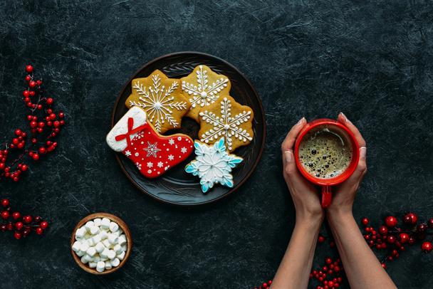hands with christmas gingerbreads and coffee  - Photo, Image