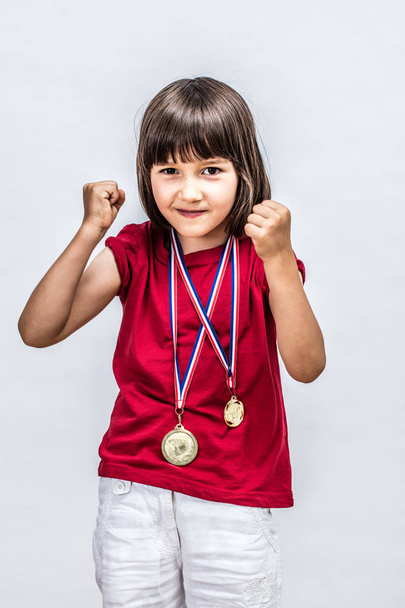 Happy successful boyish child with medals willing to win award - Foto, afbeelding