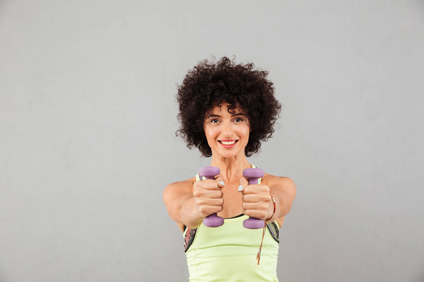 Smiling fitness woman doing exercise with dumbbells - Valokuva, kuva
