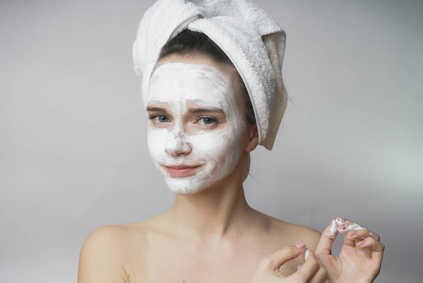 Verrast vrouw krijgt wit masker op het gezicht, scrub toepassen - Foto, afbeelding