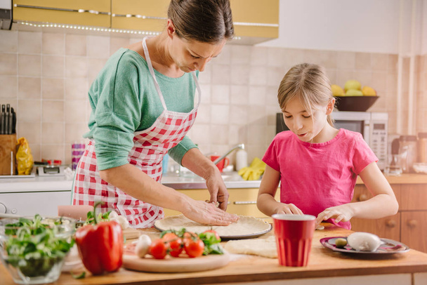 Madre e hija cocinando en casa
 - Foto, imagen