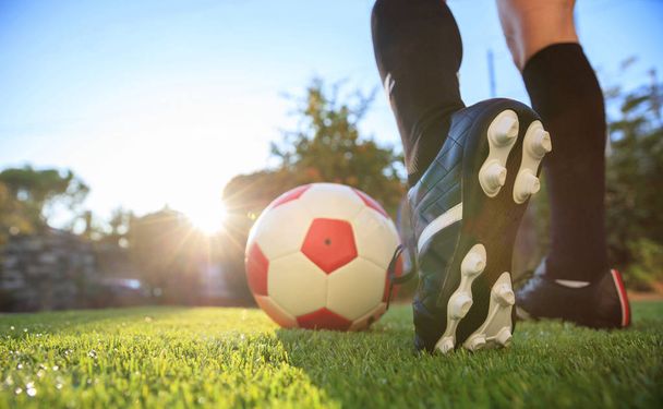 Mujer y una pelota de fútbol en la hierba
 - Foto, imagen