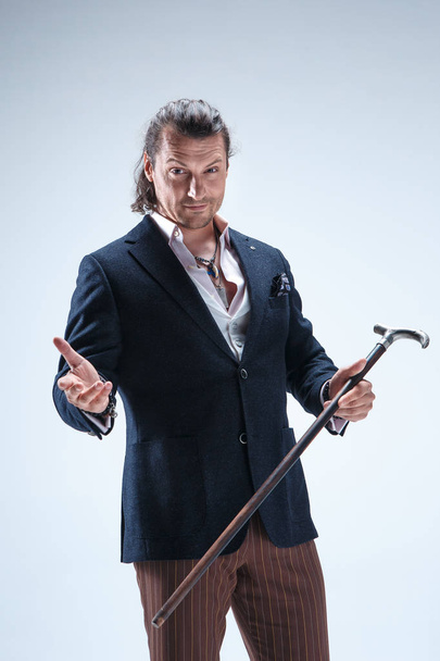 The mature barded man in a suit holding cane. - 写真・画像