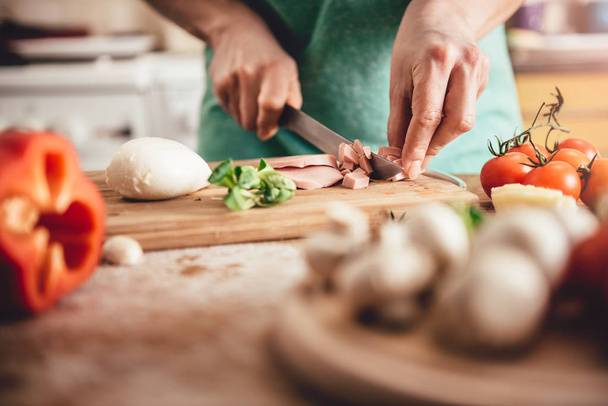 Woman slicing salami  - Фото, изображение