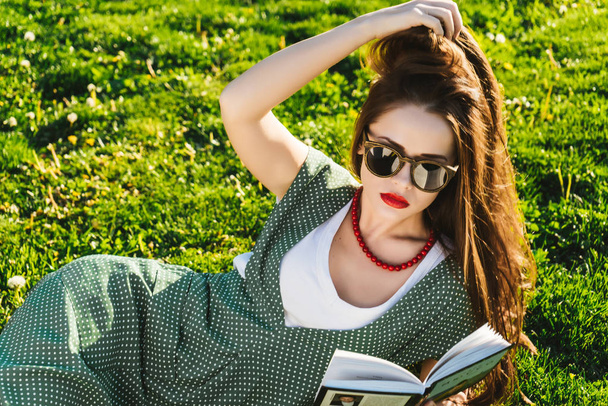 Reading woman on grass.Preparing student in park,sun glasses - Foto, Imagen