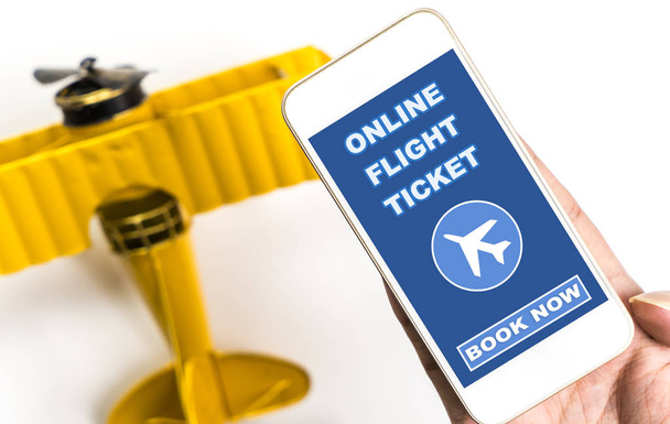 Online uçuş bilet Rezervasyonunuzu şimdi üstünde hareket eden telefon ile metal uçak - Fotoğraf, Görsel
