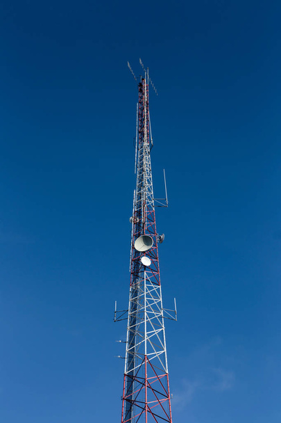 High antenna tower used for various signals and blue sky in background. - Foto, immagini