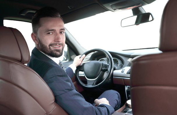 businessman sitting at the wheel of a prestigious car - Фото, изображение