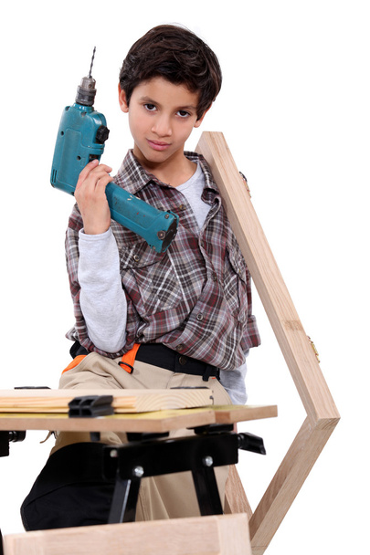 Little boy dressed like a craftsman holding a drill - Fotoğraf, Görsel