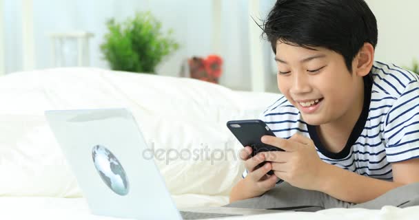 Smartphone ve daktilo ile gülümsemek yüz holding sevimli Asya çocuk eller. - Video, Çekim
