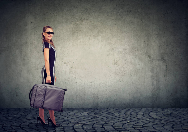 beautiful young woman with suitcase ready to explore city  - 写真・画像