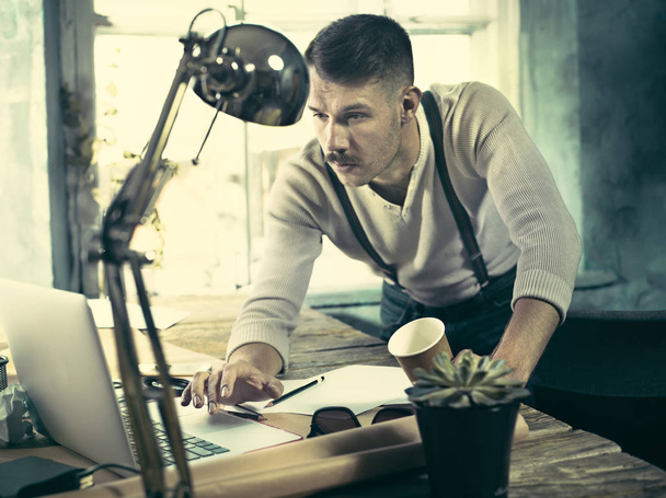 Architect working on drawing table in office - Foto, afbeelding