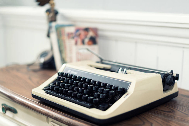 Máquina de escribir vintage y libros sobre la mesa en casa
. - Foto, Imagen