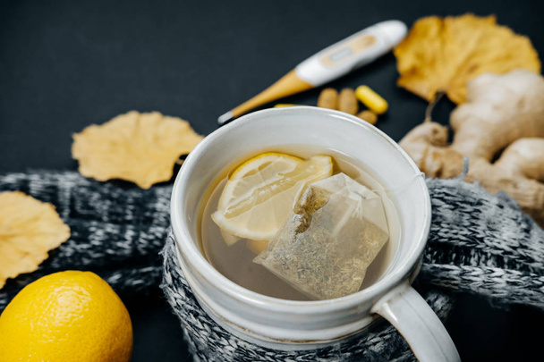 Closeup Tea with lemon, thermometer, ginger, scarf, tablets and  - Fotografie, Obrázek