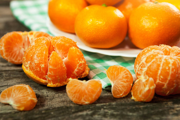 Peeled fresh clementines with kitchen cloth - 写真・画像
