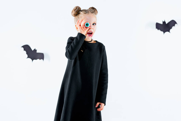 Little girl witch in black dress over magical accessories. Halloween, the studio evening. - Fotografie, Obrázek