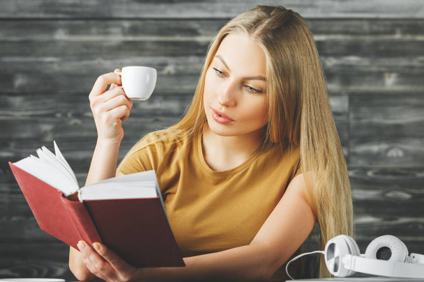 European woman reading book at desk  - Photo, Image