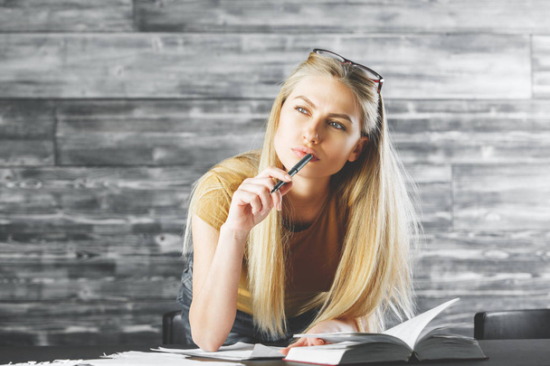 Thoughtful woman with book doing paperwork  - Photo, Image