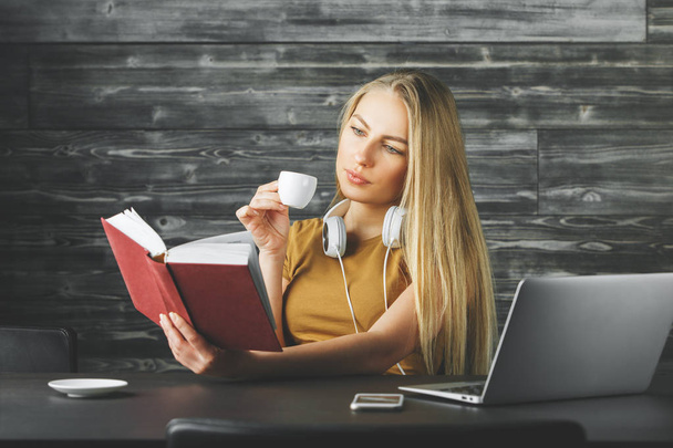 White woman reading book at desk  - Foto, Bild