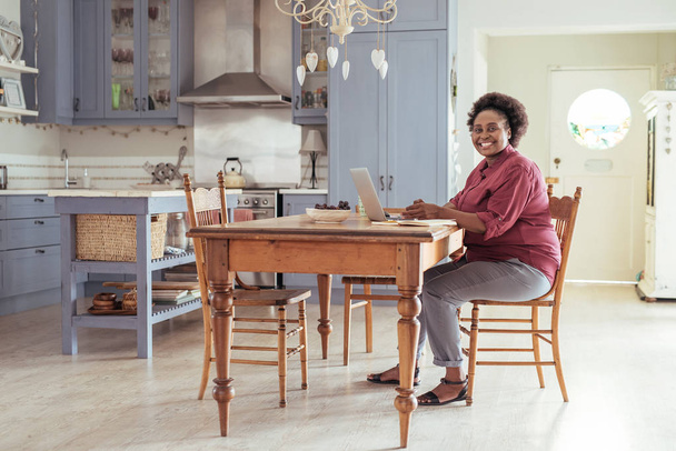 woman sitting in kitchen  - Фото, изображение