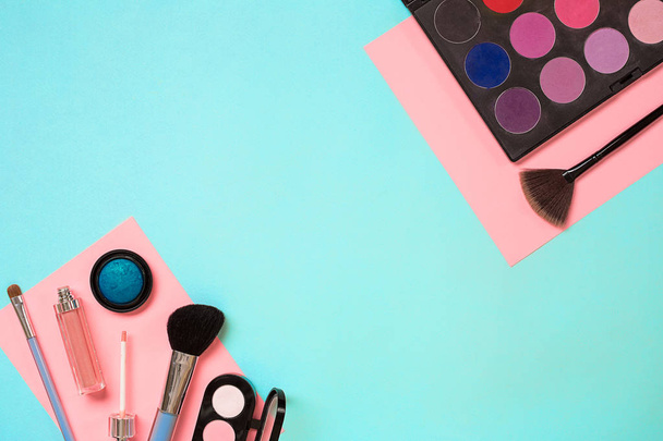 Maquille les choses essentielles. Set de pinceaux de maquillage professionnels, crèmes et ombres en pots sur fond bleu
. - Photo, image
