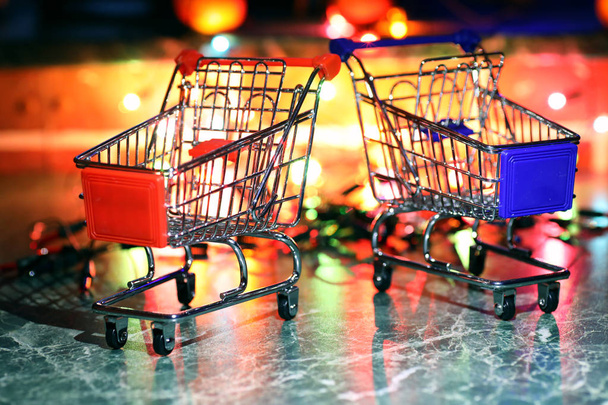 metal supermarket small cart on a background colored lights - Φωτογραφία, εικόνα