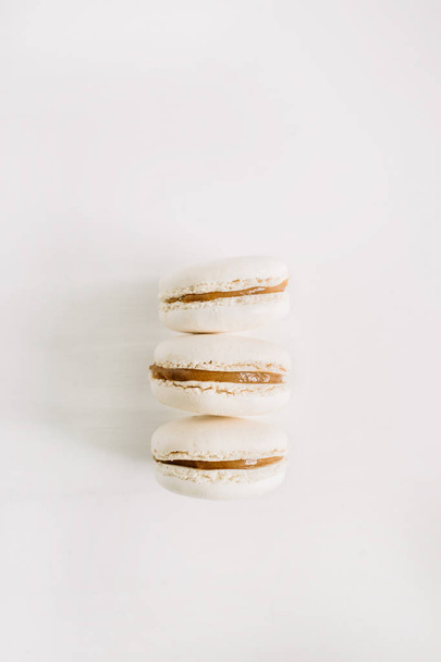 Drie pastel beige bitterkoekjes op wit - Foto, afbeelding