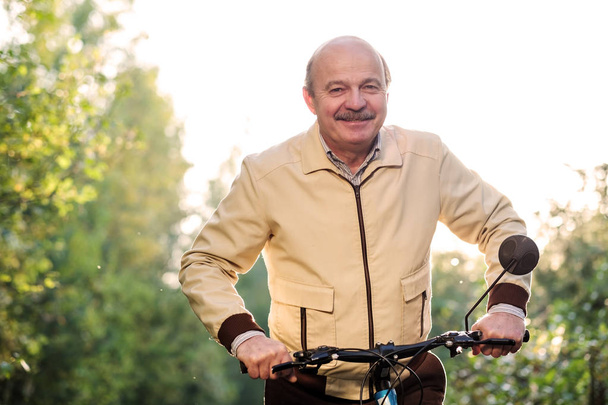 Старший чоловік під час їзди на велосипеді в сільській місцевості
 - Фото, зображення