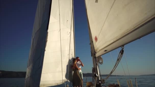 Kamera sevgi dolu genç çift bir yelkenli üzerinde kucaklayan hareket ediyor. - Video, Çekim