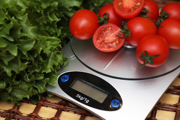 Fresh tomatoes on kitchen scales weighing - Photo, Image