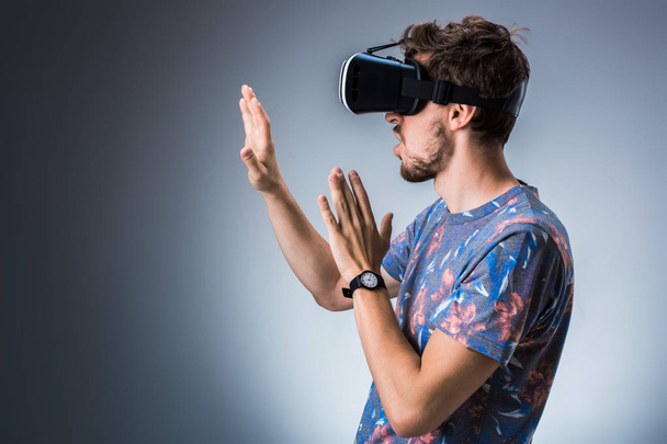 Side view of a young guy using a VR headset. Emotions - Foto, imagen