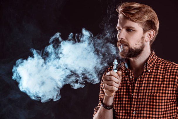 fiatal férfi dohányzik elektronikus cigaretta - Fotó, kép