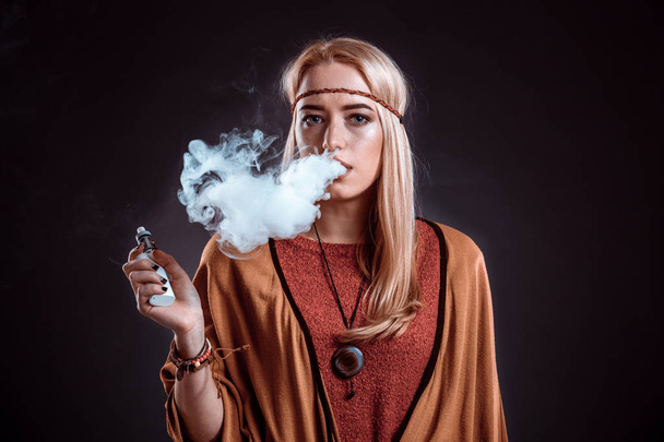 Jeune femme dans le style Boho soufflant la fumée
 - Photo, image