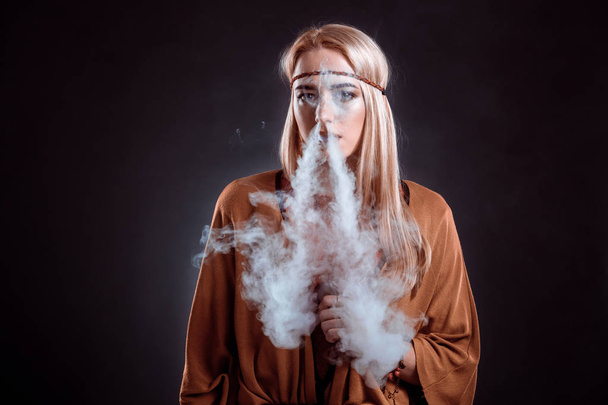 Młoda kobieta w stylu Boho, dmuchanie dymem - Zdjęcie, obraz